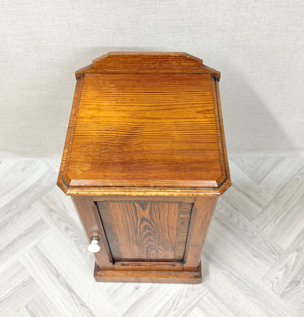 An antique pine pot cupboard featuring a single panelled door with a white ceramic knob, set on a solid plinth base. View IV