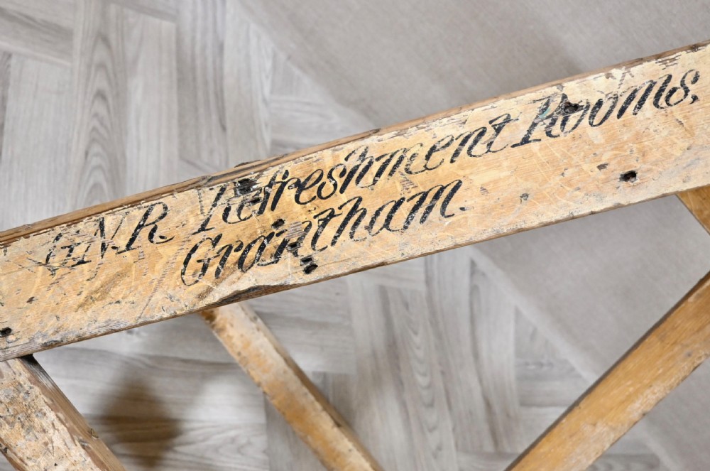 Light pine wooden step ladder featuring an extended vertical handrail pole and hand-painted black lettering along the side frame. View V