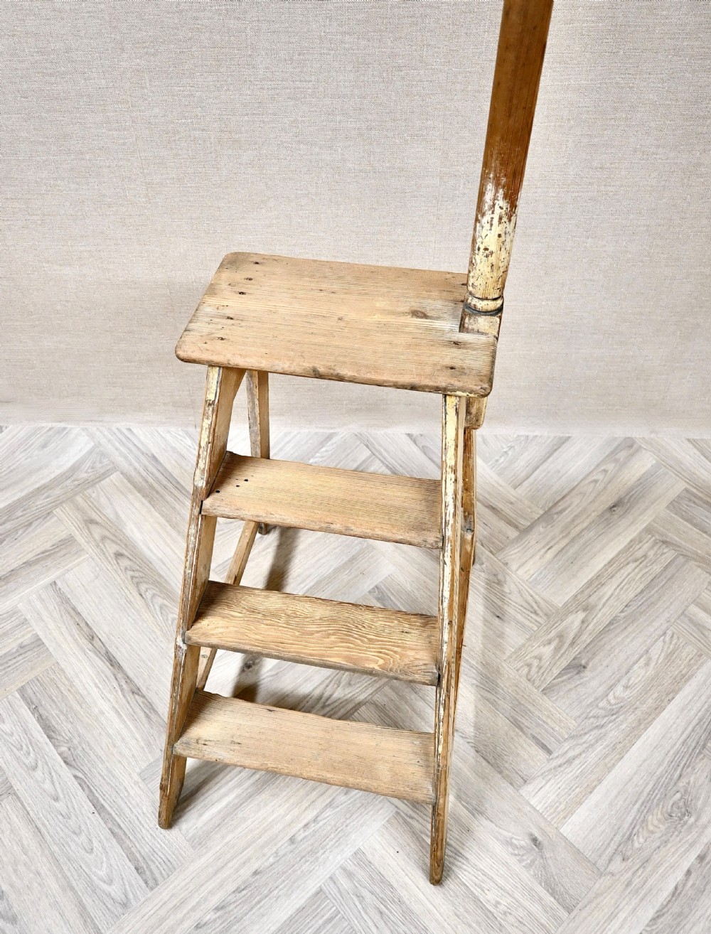Light pine wooden step ladder featuring an extended vertical handrail pole and hand-painted black lettering along the side frame. View VI