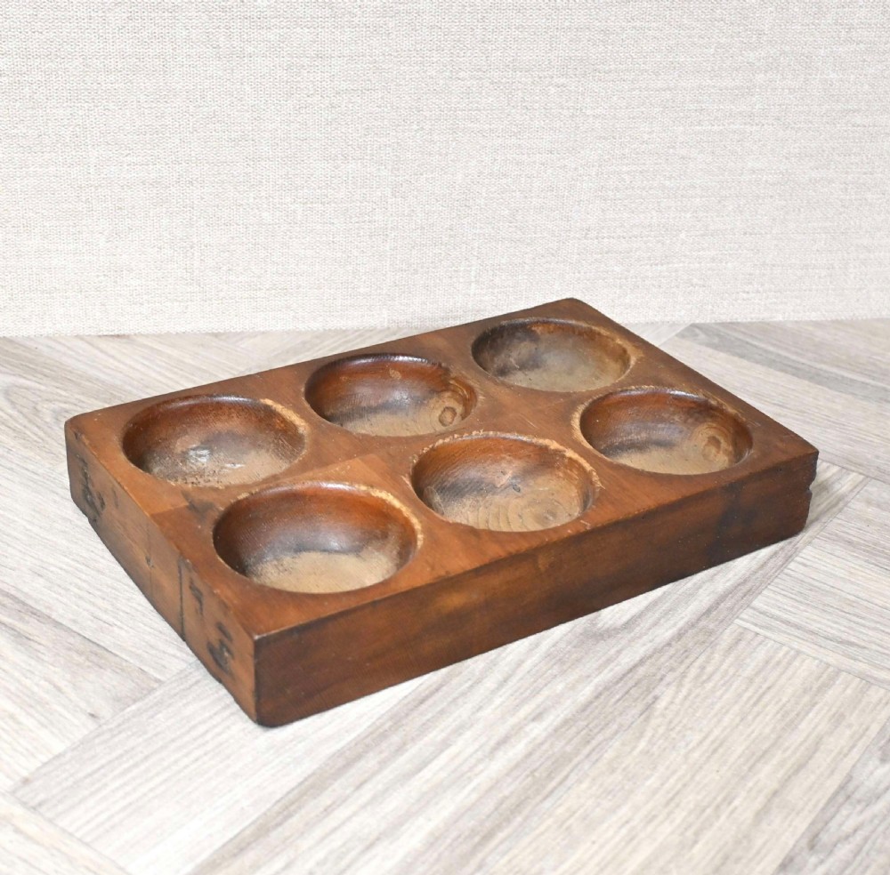 A rectangular wooden tray featuring six carved circular recessed wells for holding coins or small desktop items. View II