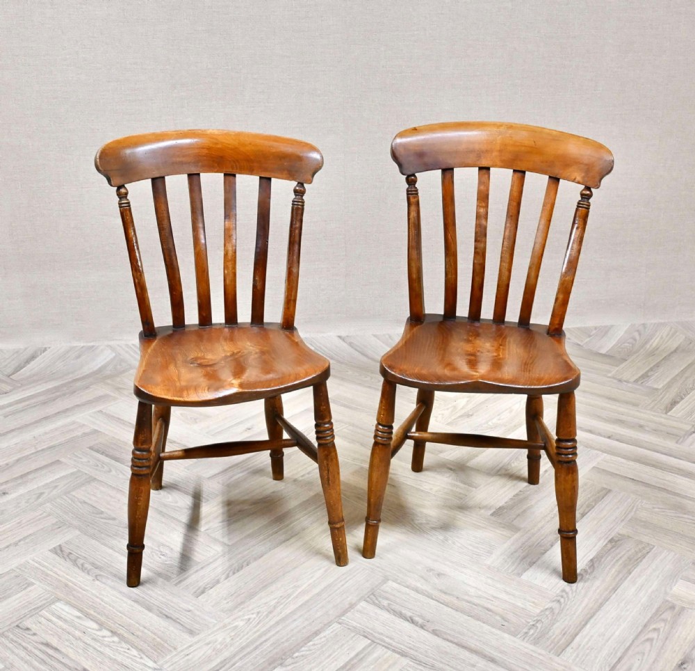 A pair of antique wooden Windsor kitchen chairs with curved top rails, vertical back spindles, shaped seats, and turned legs. View II