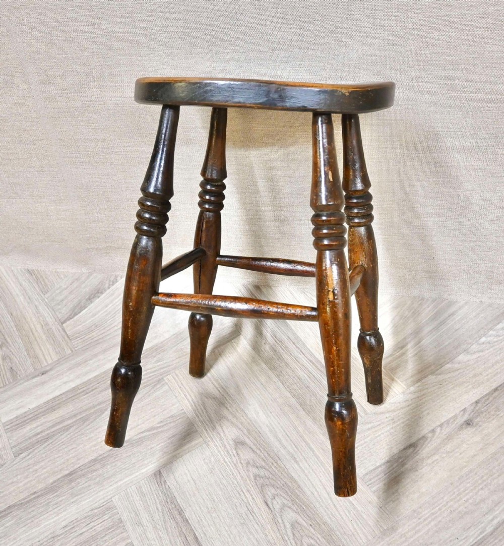 A 19th-century dark wood Windsor country stool with an oval seat, turned legs, and stretchers. View II