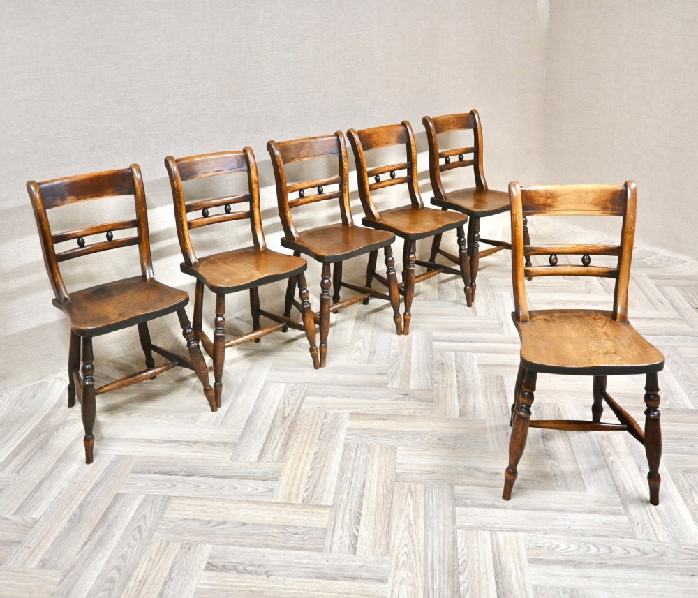 A set of six matching antique wooden Windsor barback dining chairs featuring turned legs, horizontal back rails with central bobbin detail, and contoured wooden seats. View II