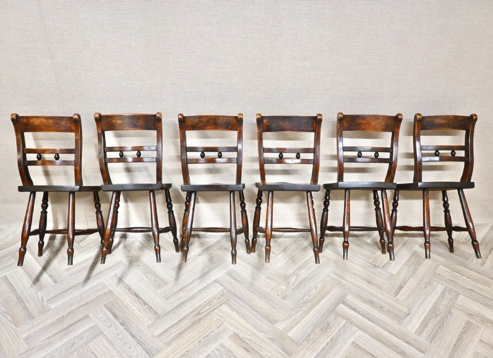 A set of six matching antique wooden Windsor barback dining chairs featuring turned legs, horizontal back rails with central bobbin detail, and contoured wooden seats. View IV