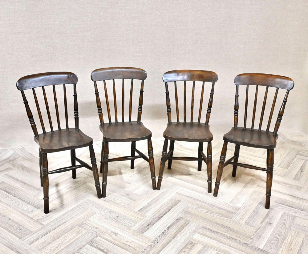 Set of four dark brown wooden Windsor stickback dining chairs with spindle backs, solid seats, and turned legs. View VI