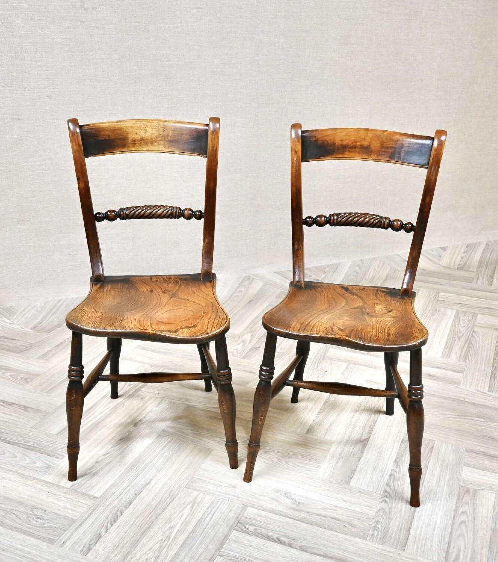 A pair of Victorian wooden kitchen chairs featuring curved top rails, carved rope-twist middle bars, shaped saddle seats, and turned legs. View II