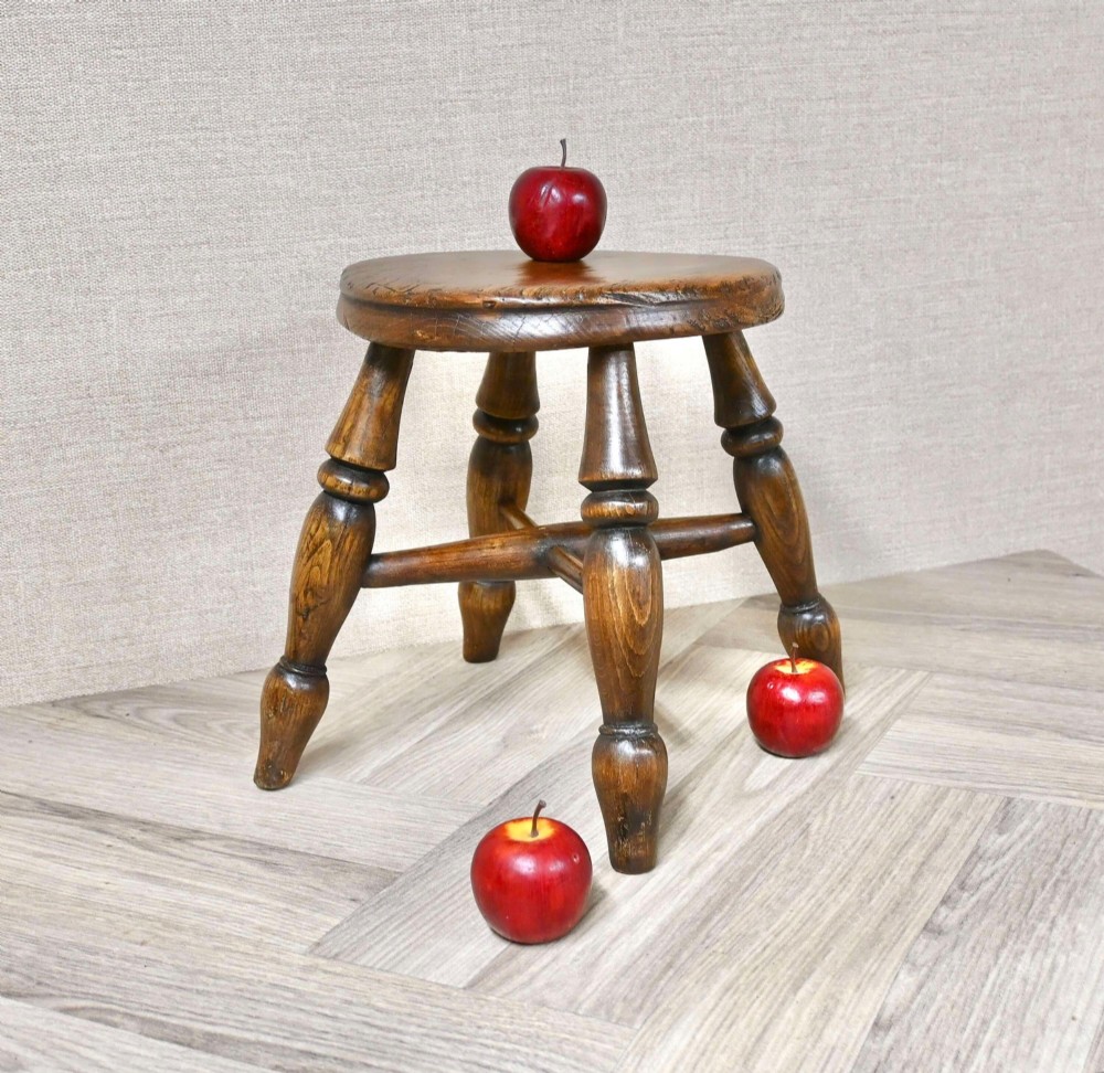 A 19th-century three-legged wooden nursery stool featuring turned legs, cross stretchers, and a circular top. View II
