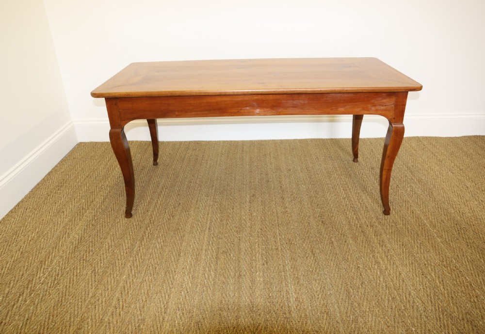 An antique French cherrywood farmhouse dining table featuring slender cabriole legs, an end drawer, and an extending pull-out slide. View II