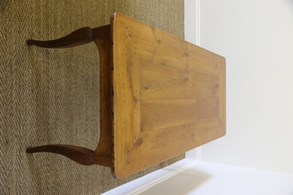 An antique French cherrywood farmhouse dining table featuring slender cabriole legs, an end drawer, and an extending pull-out slide. View III