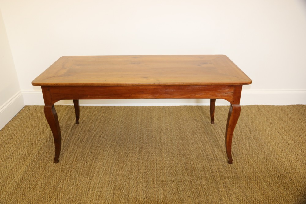 An antique French cherrywood farmhouse dining table featuring slender cabriole legs, an end drawer, and an extending pull-out slide. View VII