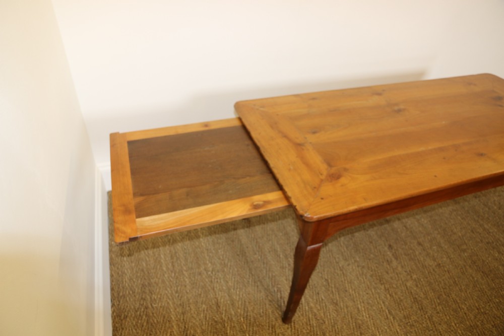An antique French cherrywood farmhouse dining table featuring slender cabriole legs, an end drawer, and an extending pull-out slide. View VIII
