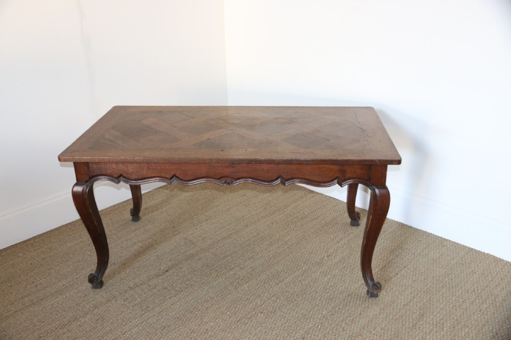 A rectangular dark oak table featuring an inlaid parquet pattern top, a scalloped apron, and sweeping cabriole legs with scroll feet. View III