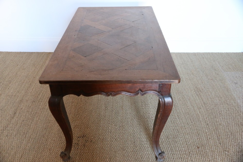 A rectangular dark oak table featuring an inlaid parquet pattern top, a scalloped apron, and sweeping cabriole legs with scroll feet. View XII