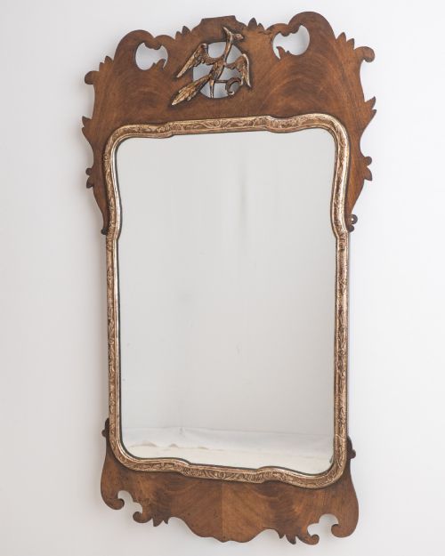 fig 1. A George II style walnut fretwork pier mirror featuring a carved parcel-gilt hoho bird motif on the crest and a gilded inner moulding.