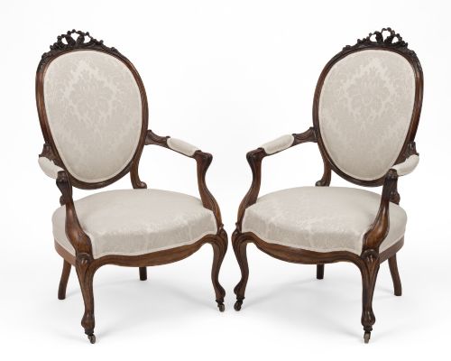 fig 1. A pair of mid-19th century English rosewood Rococo Revival open armchairs with oval damask backs, carved top crests, padded arms, and cabriole legs on castors.