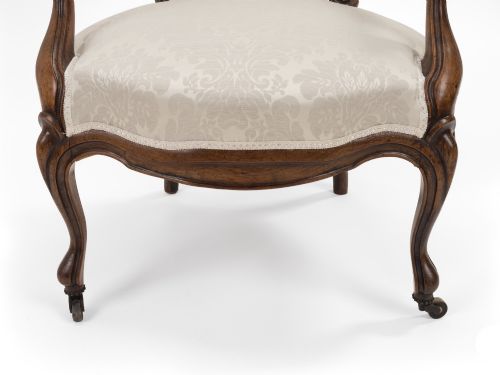fig 4. A pair of mid-19th century English rosewood Rococo Revival open armchairs with oval damask backs, carved top crests, padded arms, and cabriole legs on castors.