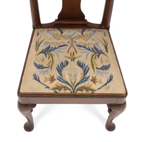 fig 2. A George II walnut side chair featuring a shaped vasiform splat, cabriole front legs with pad feet, turned stretchers, and a floral needlework drop-in seat.