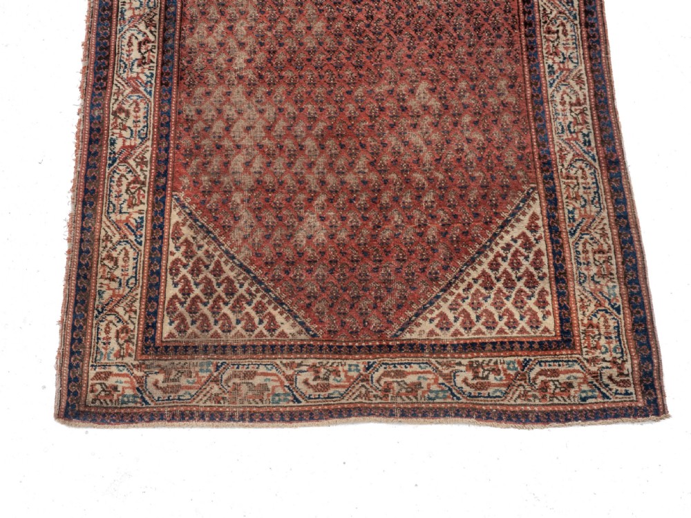 A rectangular late 19th-century handwoven Persian Mir Seraband rug featuring a repeating boteh pattern in terracotta red, blue, and cream. View II