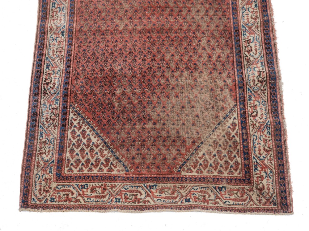 A rectangular late 19th-century handwoven Persian Mir Seraband rug featuring a repeating boteh pattern in terracotta red, blue, and cream. View III