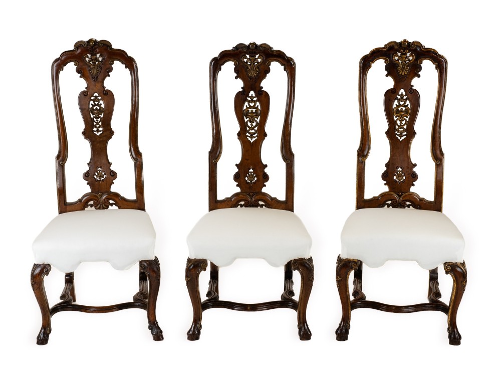 A set of six tall carved walnut dining chairs featuring gilt highlights, pierced splats, and white fabric drop-in seats. View II