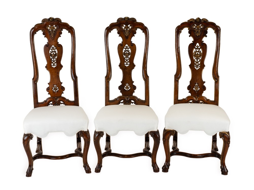 A set of six tall carved walnut dining chairs featuring gilt highlights, pierced splats, and white fabric drop-in seats. View III