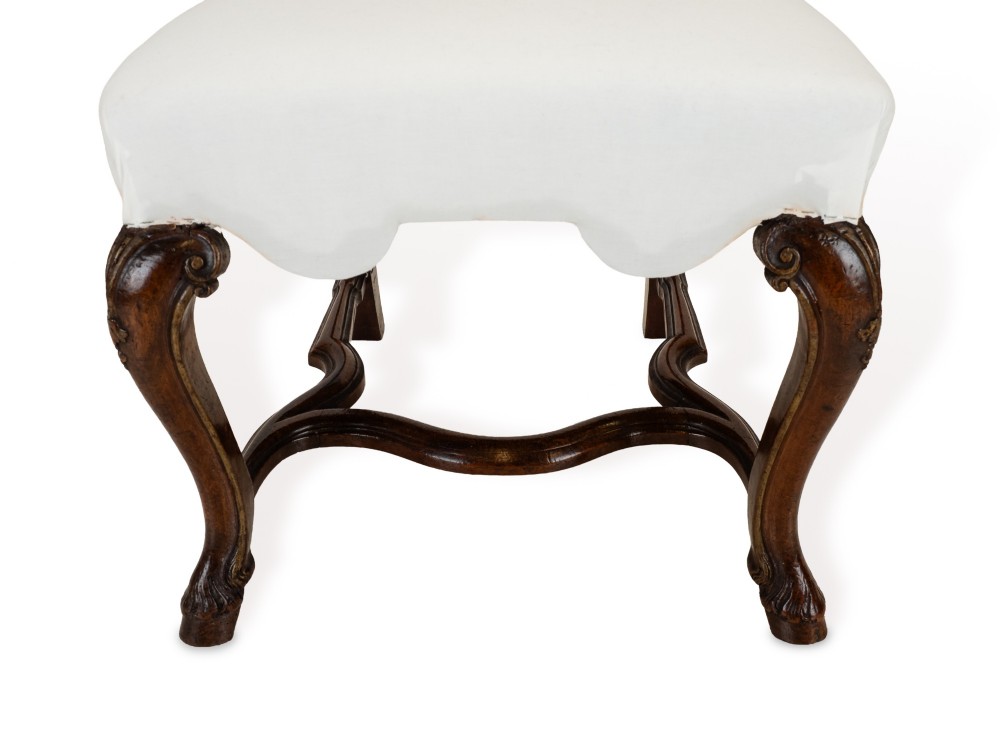 A set of six tall carved walnut dining chairs featuring gilt highlights, pierced splats, and white fabric drop-in seats. View VIII