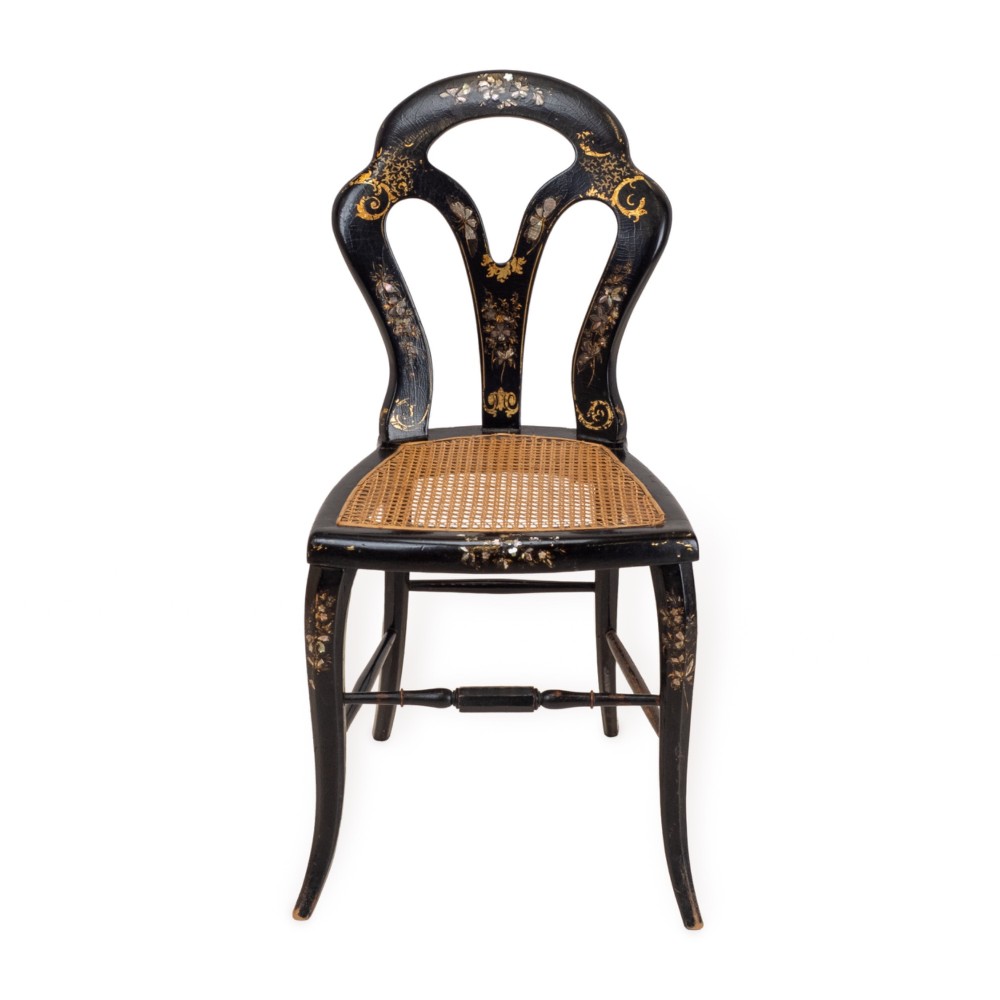 A black japanned papier-mache side chair with mother-of-pearl floral inlay, gold leaf flourishes, a openwork backrest, cabriole front legs, and a woven cane seat.