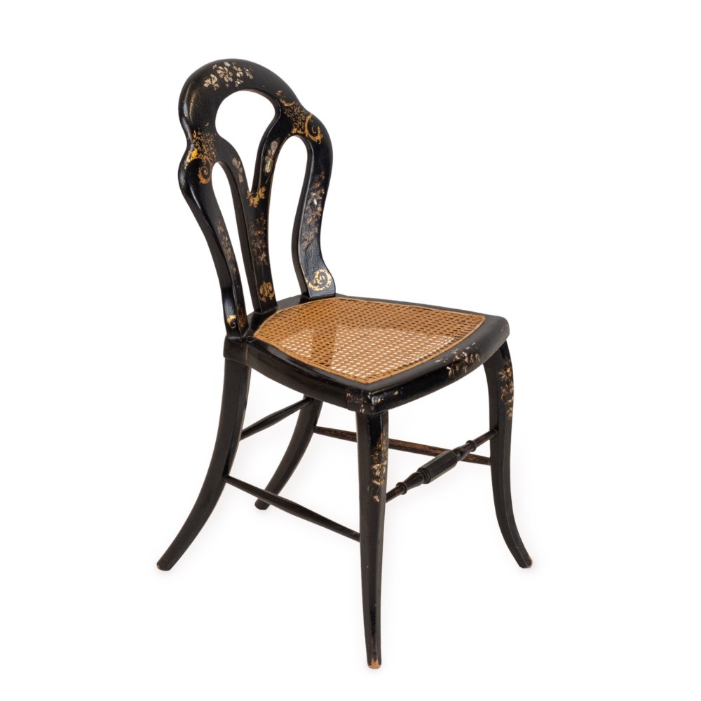 A black japanned papier-mache side chair with mother-of-pearl floral inlay, gold leaf flourishes, a openwork backrest, cabriole front legs, and a woven cane seat. View III
