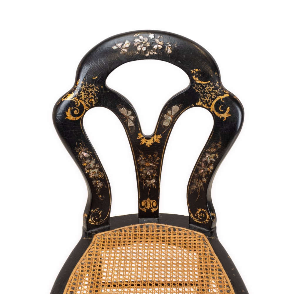 A black japanned papier-mache side chair with mother-of-pearl floral inlay, gold leaf flourishes, a openwork backrest, cabriole front legs, and a woven cane seat. View IV