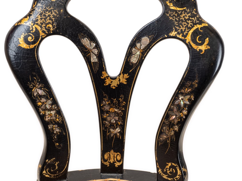 A black japanned papier-mache side chair with mother-of-pearl floral inlay, gold leaf flourishes, a openwork backrest, cabriole front legs, and a woven cane seat. View VII