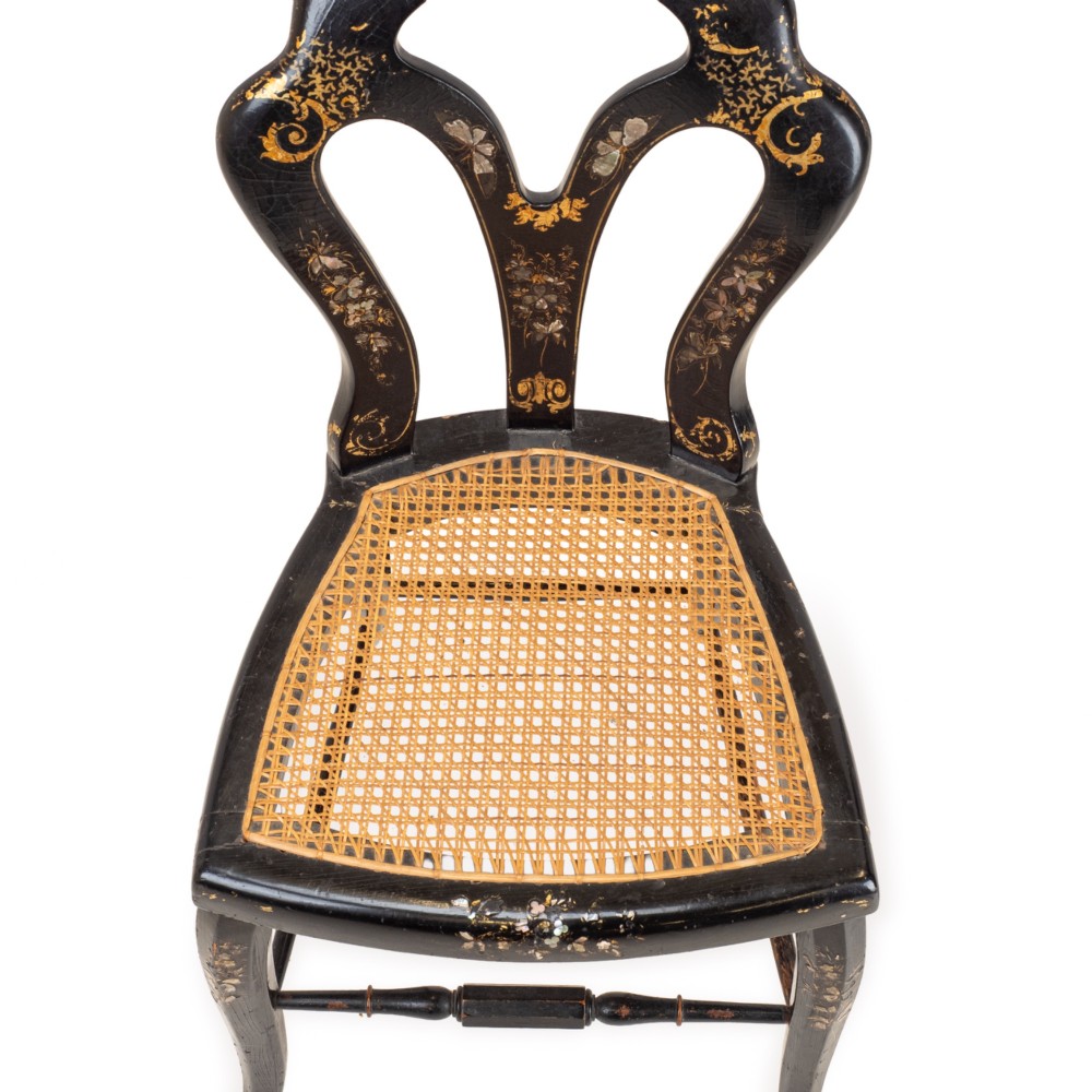 A black japanned papier-mache side chair with mother-of-pearl floral inlay, gold leaf flourishes, a openwork backrest, cabriole front legs, and a woven cane seat. View VIII