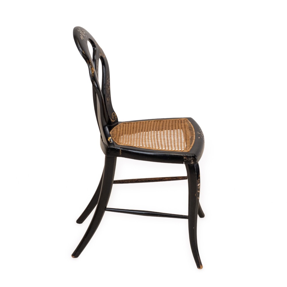 A black japanned papier-mache side chair with mother-of-pearl floral inlay, gold leaf flourishes, a openwork backrest, cabriole front legs, and a woven cane seat. View XII