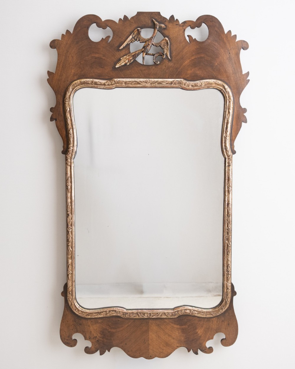 A George II style walnut fretwork pier mirror featuring a carved parcel-gilt hoho bird motif on the crest and a gilded inner moulding. View X