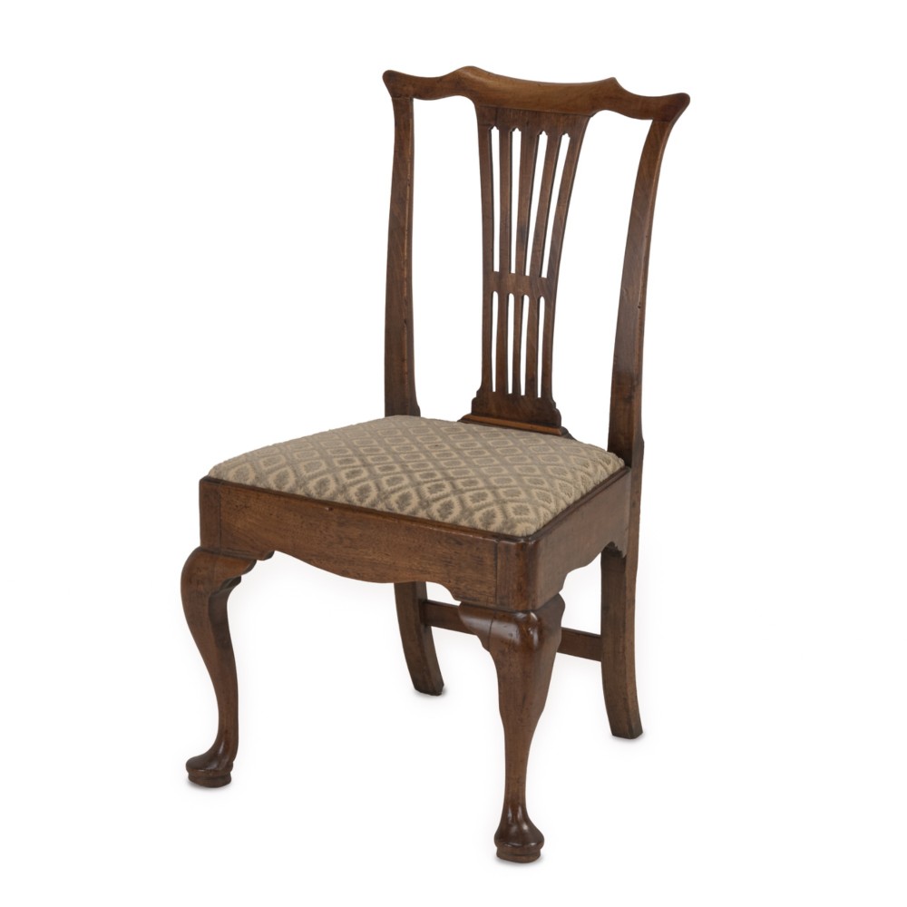 A mid-18th century English walnut side chair featuring a pierced vertical splat back, patterned upholstered seat, and cabriole front legs.