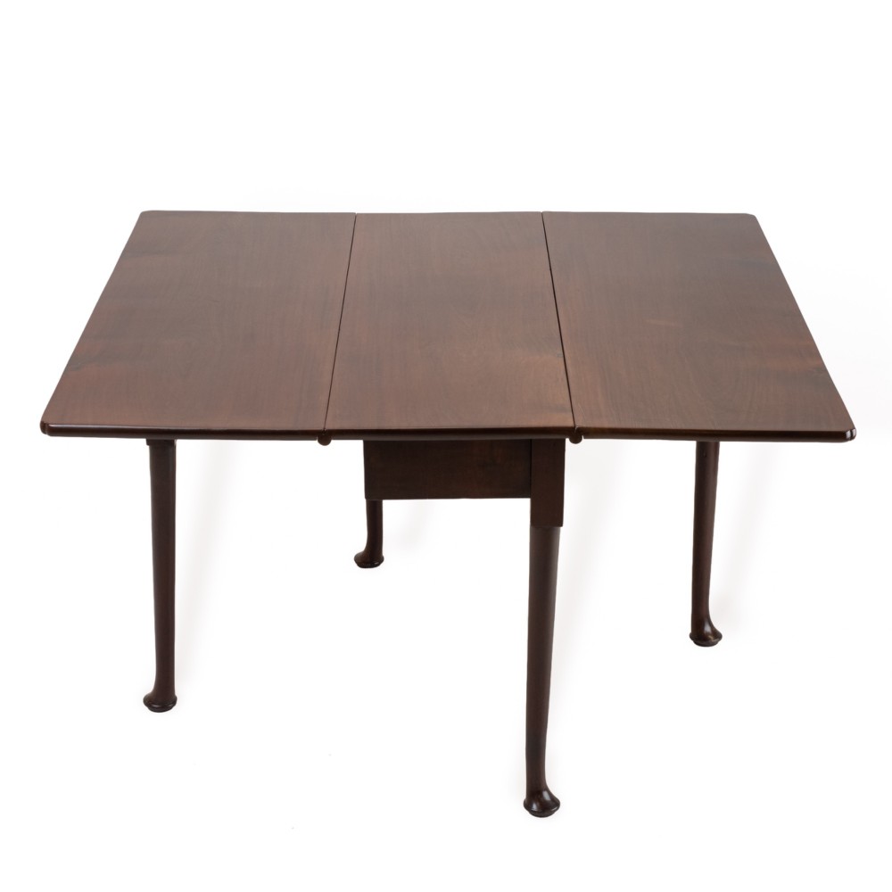 An antique dark walnut drop-leaf gateleg table shown with both extension leaves fully raised and slender turned legs. View IV