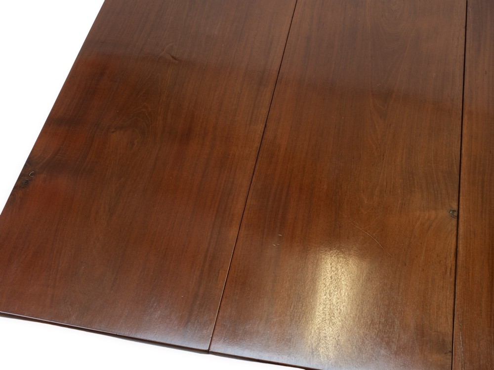 An antique dark walnut drop-leaf gateleg table shown with both extension leaves fully raised and slender turned legs. View VII