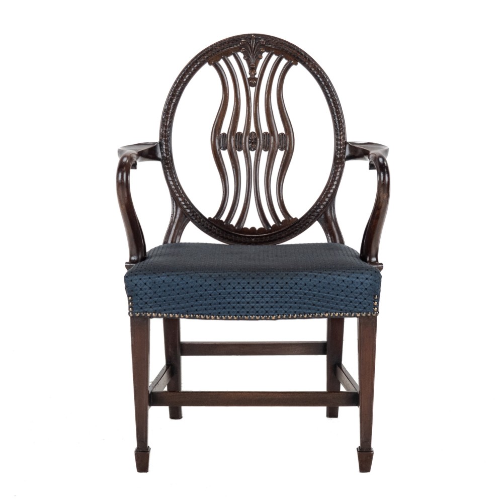 A pair of late 19th-century mahogany Hepplewhite-style carver armchairs featuring carved oval backs and navy blue upholstered seats with brass studding. View III