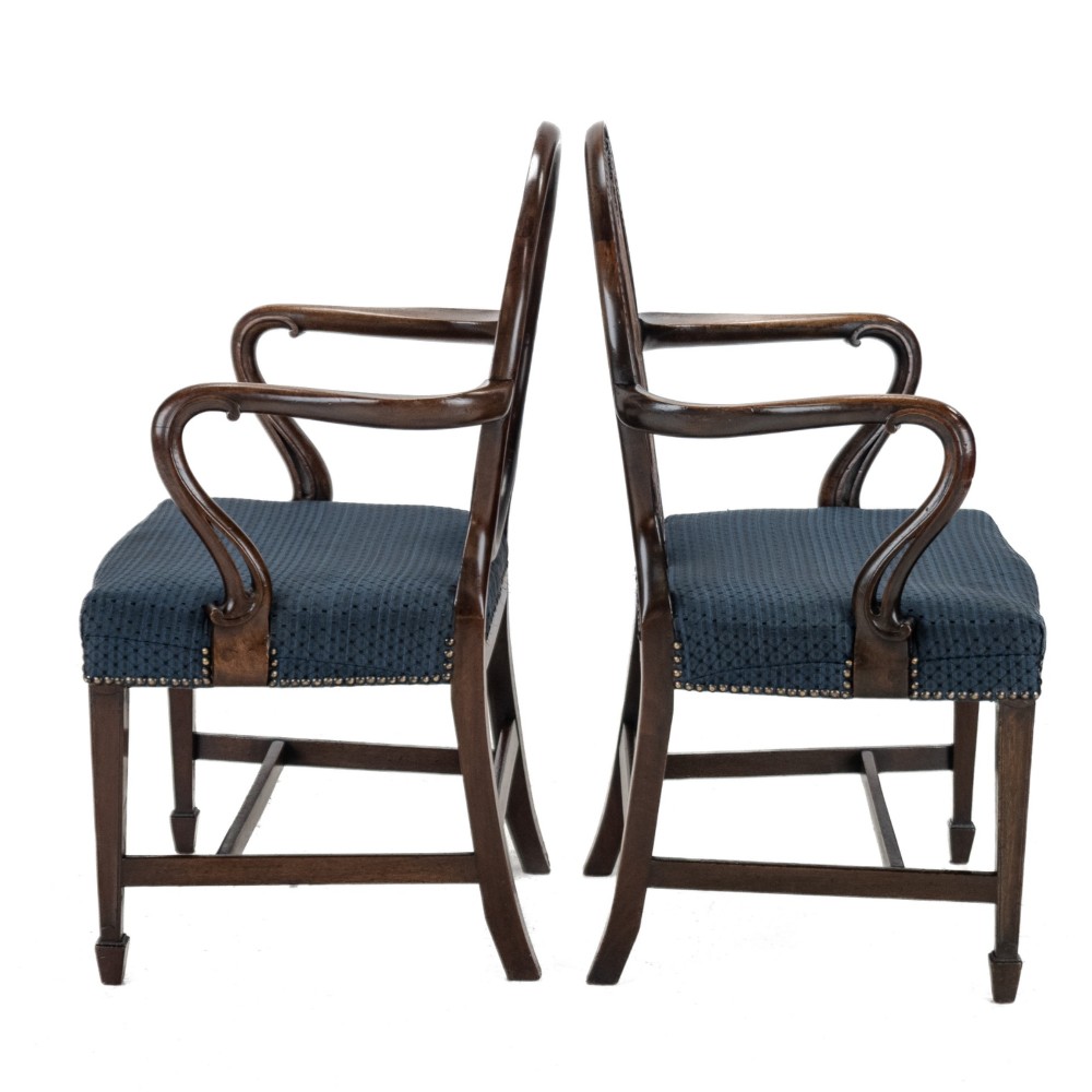 A pair of late 19th-century mahogany Hepplewhite-style carver armchairs featuring carved oval backs and navy blue upholstered seats with brass studding. View IV