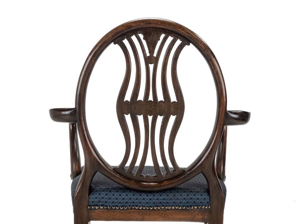 A pair of late 19th-century mahogany Hepplewhite-style carver armchairs featuring carved oval backs and navy blue upholstered seats with brass studding. View VI