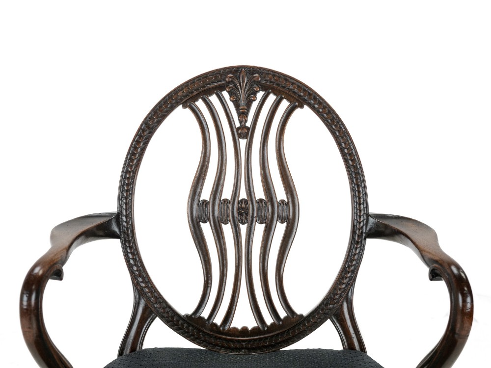 A pair of late 19th-century mahogany Hepplewhite-style carver armchairs featuring carved oval backs and navy blue upholstered seats with brass studding. View VIII