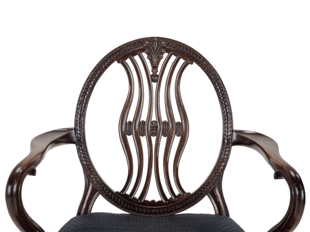 A pair of late 19th-century mahogany Hepplewhite-style carver armchairs featuring carved oval backs and navy blue upholstered seats with brass studding. View IX