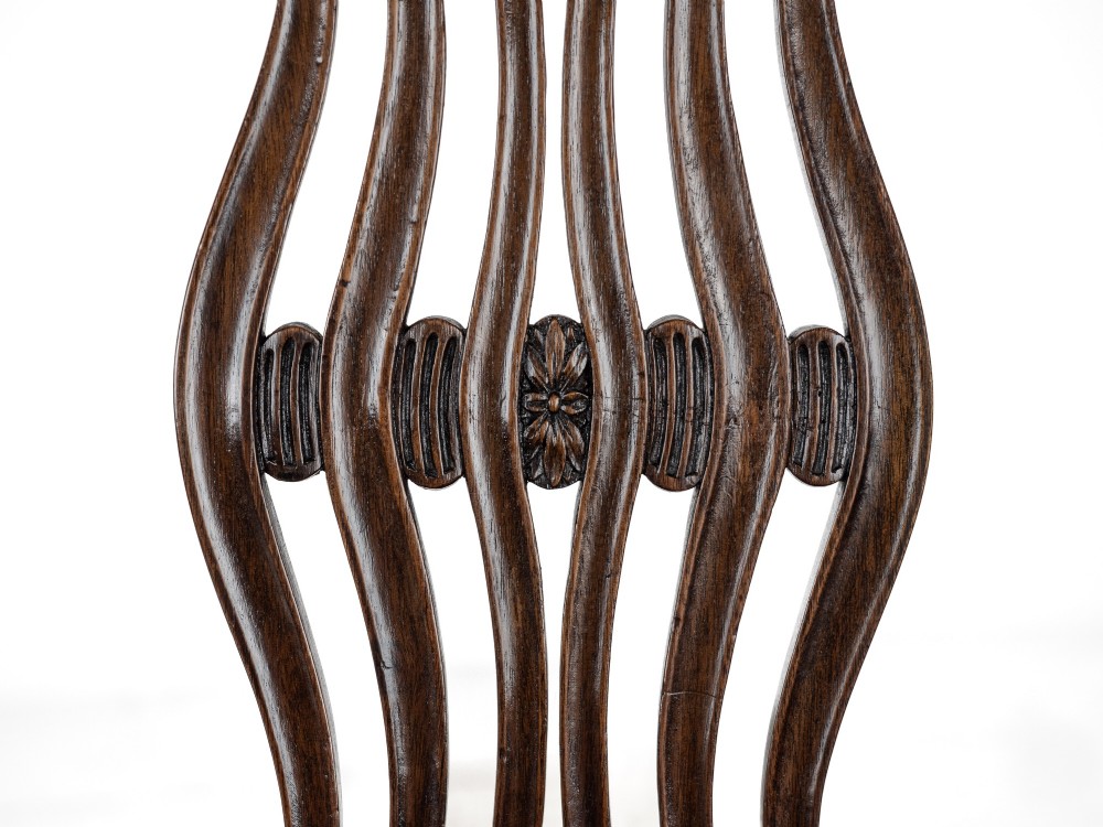 A pair of late 19th-century mahogany Hepplewhite-style carver armchairs featuring carved oval backs and navy blue upholstered seats with brass studding. View XI