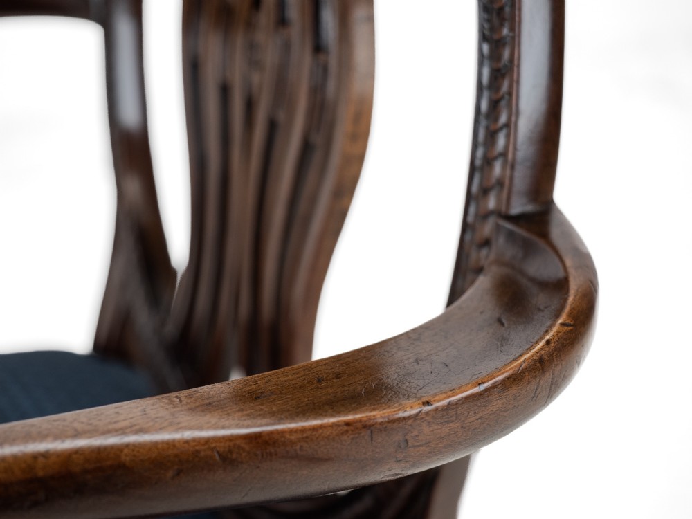 A pair of late 19th-century mahogany Hepplewhite-style carver armchairs featuring carved oval backs and navy blue upholstered seats with brass studding. View XII