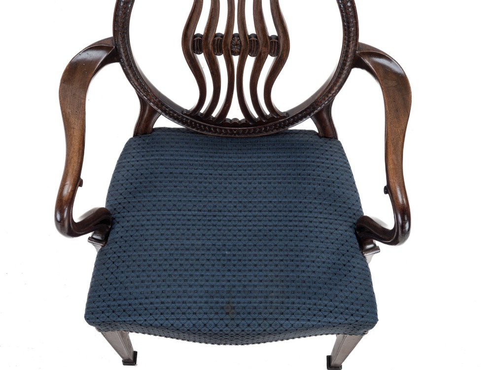 A pair of late 19th-century mahogany Hepplewhite-style carver armchairs featuring carved oval backs and navy blue upholstered seats with brass studding. View XIV