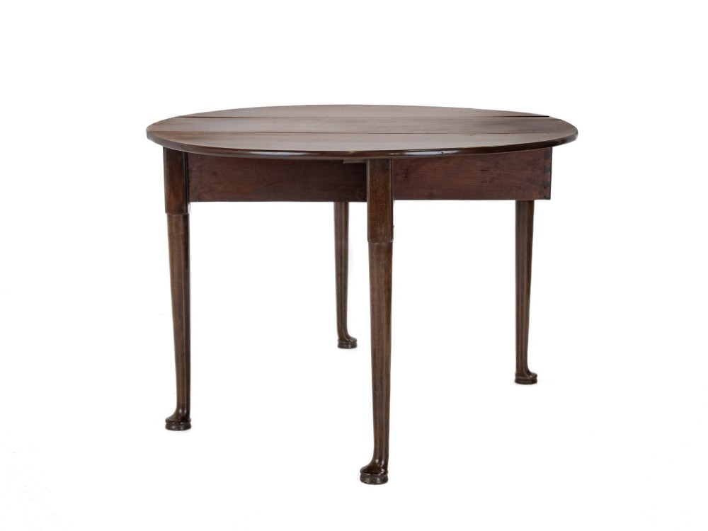 A George II mid-18th century dark mahogany oval drop-leaf table with slender legs ending in pad feet. View VI
