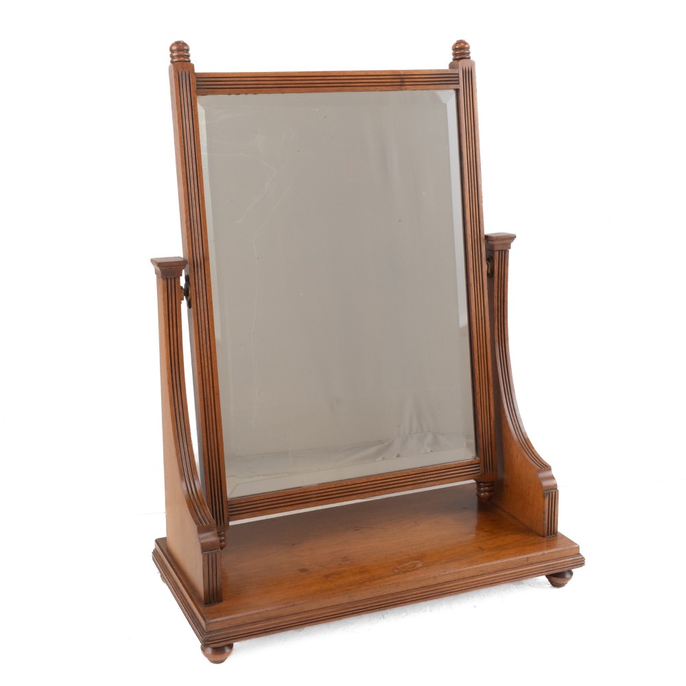 A late 19th-century mahogany table top dressing mirror featuring fluted upright columns, finials, a bevelled rectangular mirror plate, and a moulded wooden base on bun feet. View III