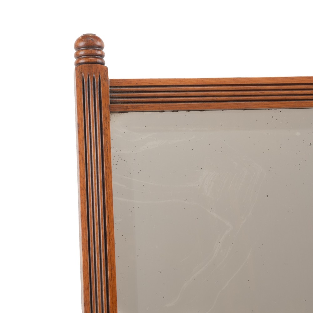A late 19th-century mahogany table top dressing mirror featuring fluted upright columns, finials, a bevelled rectangular mirror plate, and a moulded wooden base on bun feet. View IV
