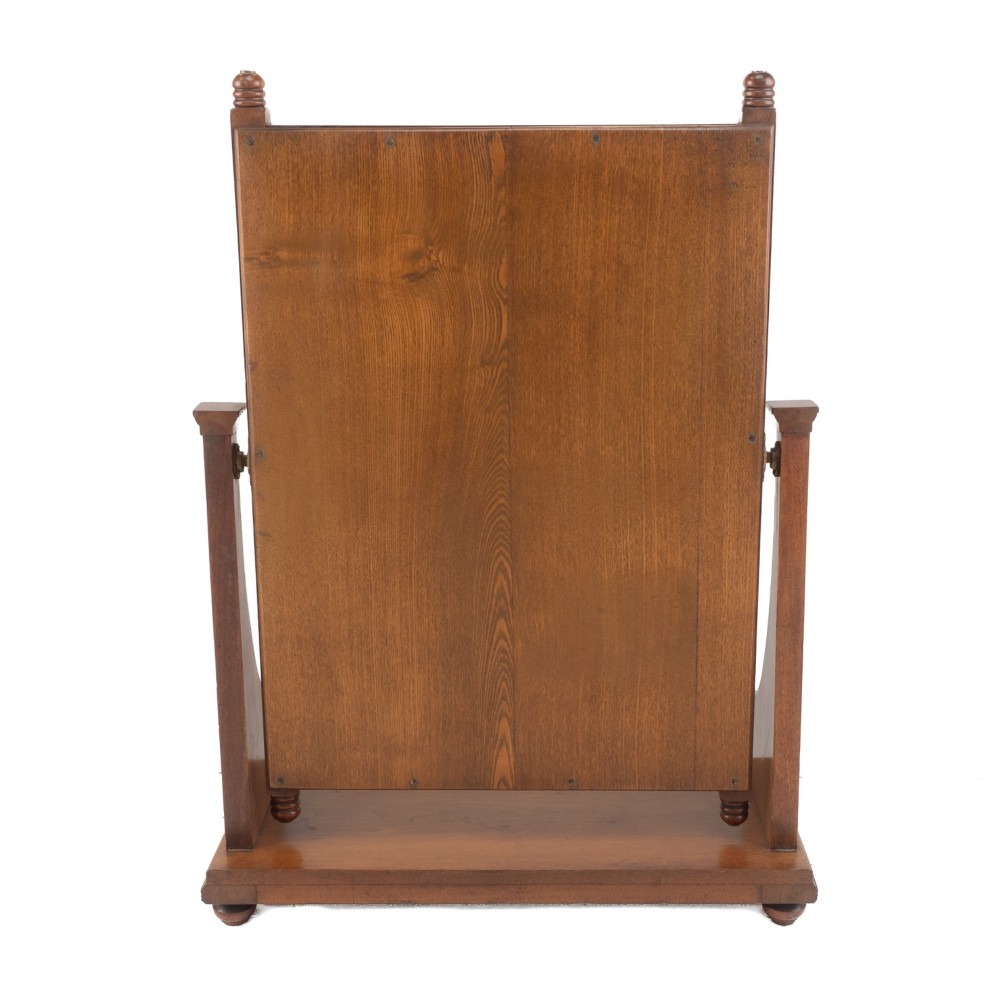 A late 19th-century mahogany table top dressing mirror featuring fluted upright columns, finials, a bevelled rectangular mirror plate, and a moulded wooden base on bun feet. View VII