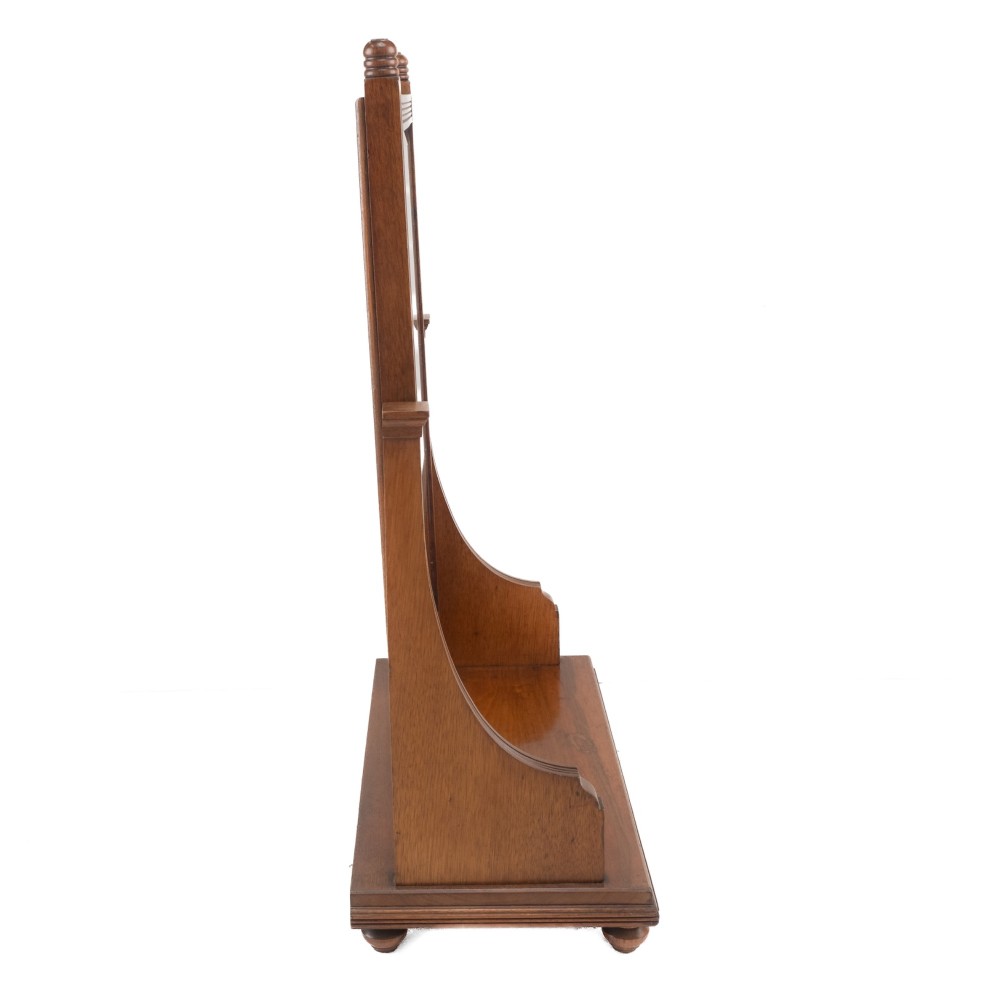 A late 19th-century mahogany table top dressing mirror featuring fluted upright columns, finials, a bevelled rectangular mirror plate, and a moulded wooden base on bun feet. View IX