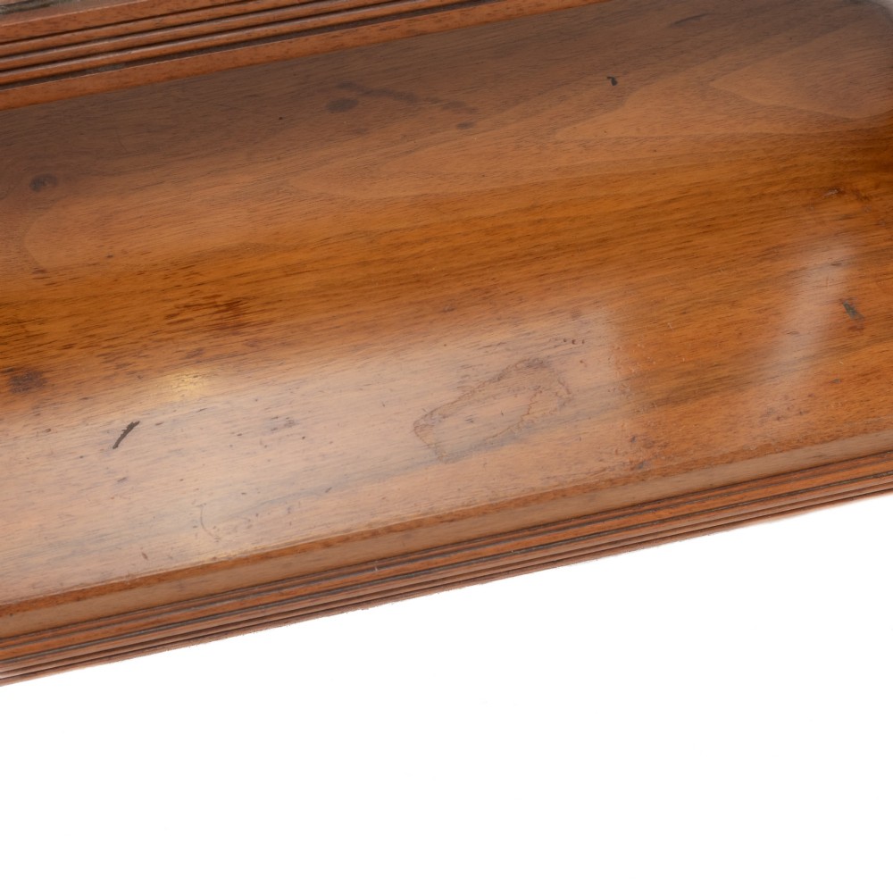 A late 19th-century mahogany table top dressing mirror featuring fluted upright columns, finials, a bevelled rectangular mirror plate, and a moulded wooden base on bun feet. View X